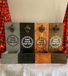 four wooden boxes with magnets on them sitting next to a red and black checkered curtain