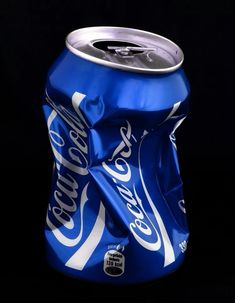 a close up of a can of soda on a black background