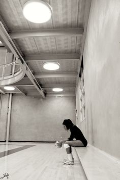 a woman squatting down on the floor in an empty room with words reading, good sportsmanship leads to success