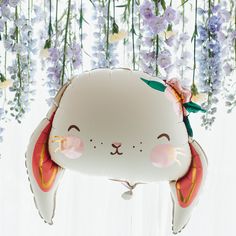 a balloon shaped like a cat with flowers hanging from it's sides and eyes