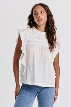 image of a female model wearing a DONNA RUFFLE SLEEVE TOP WHITE DEAR JOHN DENIM Cotton Tops With Ruffle Sleeves In Relaxed Fit, Cotton Tops With Ruffle Sleeve And Relaxed Fit, Relaxed Fit Cotton Tops With Ruffle Sleeves, Relaxed Fit Cotton Top With Ruffle Sleeves, Effortless White Top For Casual Gatherings, White Spring Blouse For Casual Gatherings, White Ruffle Sleeve Top For Daywear, Cotton Blouse With Relaxed Fit And Flutter Sleeves, Cotton Blouse With Flutter Sleeve And Relaxed Fit