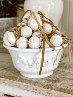 a bowl filled with white balls on top of a wooden table