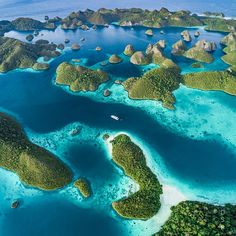 an aerial view of several islands in the ocean with blue water and green landforms