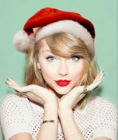 a woman wearing a santa hat with her hands on her chest