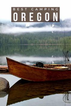 a small boat sitting on top of a lake next to a shore covered in fog