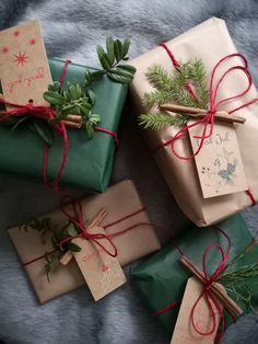 presents wrapped in brown paper and tied with red twine are sitting on a blanket