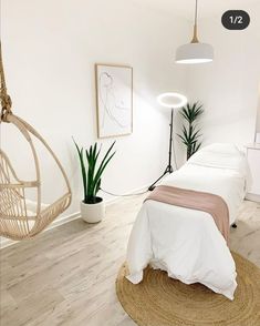 a bedroom with white walls and wood flooring has a hammock hanging from the ceiling