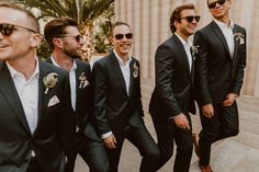 a group of men wearing suits and sunglasses