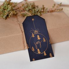 an ornament is hanging from a brown wrapping paper with gold foil on it