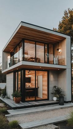 a modern house with large windows and wooden sidings on the outside, surrounded by plants