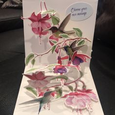 a greeting card with flowers and hummingbirds on the front, in white paper that says choose your own message