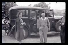 three women standing in front of an old car