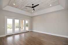 an empty living room with wood floors and ceiling fan