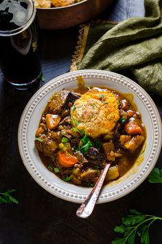 a white plate topped with meat and vegetable stew