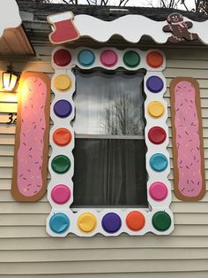 a decorated window on the side of a house with doughnuts and sprinkles