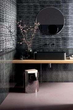 a bathroom with a sink, mirror and toilet paper dispenser in it