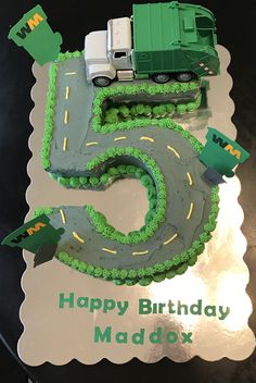 a birthday cake for a five year old with a truck and tractor on the road