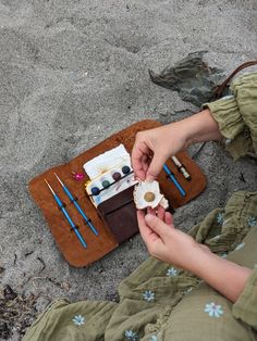 a person sitting on the ground with some food in their hands