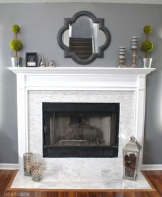 a living room with a fire place and mirror on the fireplace mantel above it