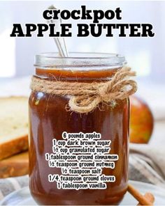 a glass jar filled with apple butter on top of a plate next to cinnamon sticks