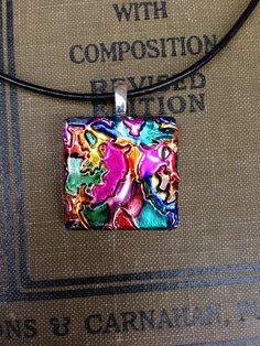 a square pendant with colorful designs on it