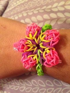 a close up of a person's arm wearing a bracelet with flowers on it