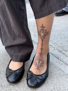 a close up of a person's foot with a tattoo on the lower leg