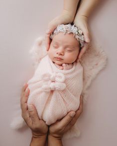 a newborn baby is being held in her mother's arms