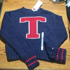 Tommy Hilfiger Sweater Is Blue With Red And White "T" On Front Chest. Ribbed Waist And Cuffs. 100% Cotton. Girl's Size Small. New With Tags. Sporty Winter School Sweater, Blue Sweater For School In Fall, Blue Fall Sweater For School, Trendy Winter Tops For School, Navy Letter Print Sweater For Winter, Navy Winter Sweater For College, Navy Winter College Sweater, Winter School Sweater With Letter Print, Tommy Hilfiger Casual Tops For College