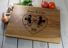 a wooden cutting board with mickey and minnie mouses on it, surrounded by vegetables