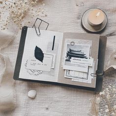 an open book sitting on top of a table next to a candle and other items