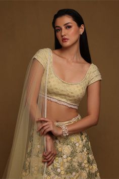 Editor's Note This floral beaded skirt set features a tulle base skirt, adorned with expensive bridal floral embroidery and is paired with a blouse embellished in crystals and pearls with crosshatch embroidery. This ensemble is completed with a tulle dupatta with delicately placed floral embroidery along the two borders and fringes on the edge. Color: Yellow Fabric: Tulle Components: Skirt, dupatta and blouse Occasion: Haldi mehndi Disclaimer: Product color may slightly vary due to photographic Crosshatch Embroidery, Beaded Lehenga, Flower Lehenga, Blouse Yoke, Neck Flower, Tulle Embroidery, Beaded Skirt, Tulle Flowers, Pearl And Lace