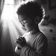 a young child is praying in the sunlight