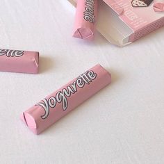 two pink candy bars sitting next to each other on a white tablecloth covered surface