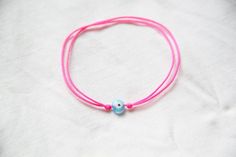 Lucky bracelet, evil eye bracelet, neon string bracelet with evil eye bead, friendship bracelet, pull-tie bracelet, neon pink string bracelet, evil eye protection bracelet, beach jewelry, lucky evil eye bracelet. This bracelet is adjustable size, handmade with handmade  evil eye glass beads and nylon cord string.This one is with neonpink string and the evil eye bead of your choice. You can also have neon yellow or royal blue string with the bead you chose. Hav a look on my others items.You can h Pink Summer Friendship Bracelets With Sliding Knot, Pink Sliding Knot Bracelet For Summer, Cute Pink Friendship Bracelets For Festivals, Cute Pink Festival Friendship Bracelets, Adjustable Pink Evil Eye Bracelet, Evil Eye String Bracelet, Bead Friendship Bracelet, Neon Bracelets, Lucky Charm Bracelet