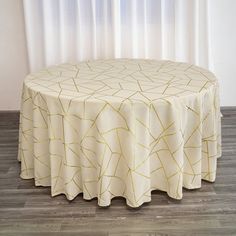 a round table with a white and gold pattern on it in front of a window