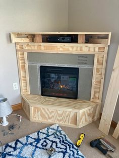 a fire place built into the side of a wall in a living room with tools on the floor