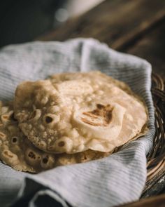 two pita breads sitting in a wicker basket