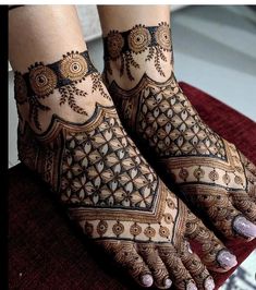 two feet with henna tattoos on them and one is showing it's intricate designs