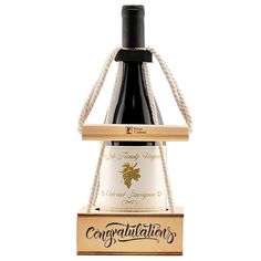 a bottle of wine sitting on top of a wooden box with rope around it and the label says congratulations