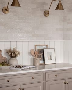 an image of a kitchen setting with white and gold decor on the counter top in front of it