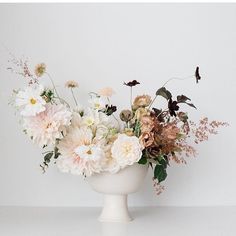 a white vase filled with lots of flowers