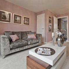 a living room filled with furniture and pictures hanging on the wall above it's coffee table