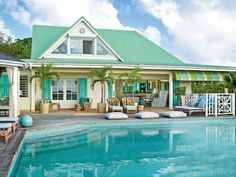 a house with a pool in front of it and some chairs around the pool area