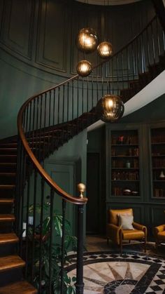 a spiral staircase in the middle of a room with two chairs and a rug on the floor