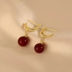 Elevate your style with these stunning red pearl dangle earrings from Barbie Brides. The 14K gold-plating and excellent cut cubic zirconia stones make these earrings perfect for any occasion - from engagements and weddings to birthdays and Valentine's Day. The intricate design and red and gold color combination add a touch of beauty and luck to any outfit, while the fairytale and fantasy theme brings a touch of whimsy. These earrings are made with nickel-free materials, ensuring that they are safe and comfortable to wear all day long. Red Pearl Earrings For Formal Occasions, Red Round Pearl Drop Earrings, Red Pearl Drop Round Earrings, Elegant Red Drop Earrings, Elegant Red Hoop Earrings For Formal Occasions, Elegant Red Pearl Earrings For Parties, Formal Red Pearl Earrings With Matching Set, Red Drop Pearl Earrings For Gift, Elegant Red Pearl Earrings For Anniversary