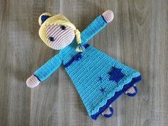 a crocheted doll laying on top of a wooden floor