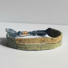 two different colored bracelets on a white surface