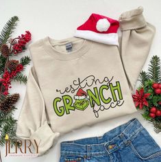 Get into the holiday spirit with our Resting Grinch Face Christmas Embroidered Sweatshirt! This funny Christmas Grinch sweatshirt is the perfect addition to your festive wardrobe. Made with high-quality materials, it is soft, comfortable, and durable, ensuring long-lasting wear throughout the holiday season. The embroidered design of the Grinch’s face adds a touch of whimsy and humor to your outfit, making it a conversation starter at any holiday gathering. Whether you’re attending a Grinch Face Sweater, Vintage Grinch, Grinch Embroidery, Embroidered Christmas Sweater, Xmas Grinch, Xmas Embroidery, Top Clothing Brands, Cute Crewneck, Grinch Face