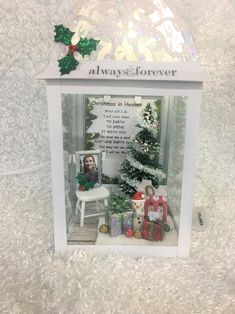 a white box with christmas decorations and presents in it's display case on the floor